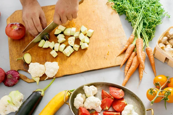 Man hands cuts vegetables for cooking vegetable stew