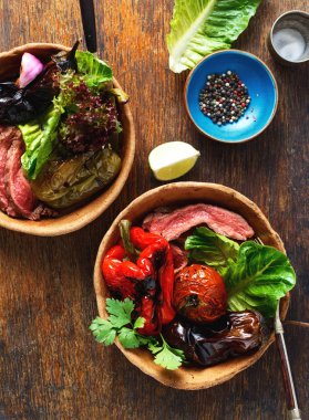 Ahşap masa, üstten görünüm tabağa ekmek ızgara biftek ızgara sebzeler ile servis