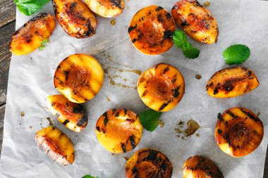 Izgara şeftali kağıt üzerine nane yaprakları ile servis üstten görünüm