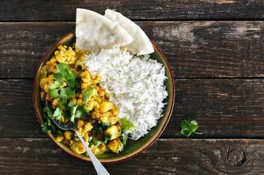 Karnabahar baharatlı köri pirinç ve naan ekmek üzerinde ahşap arka plan