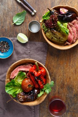 Cam kırmızı şarap ile ahşap masa ekmek tabaklarda servis ızgara sebzeli ızgara biftek.