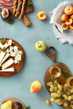 Mavi taş zemin üzerine çeşitli şarap aperatifler üstten görünüm.