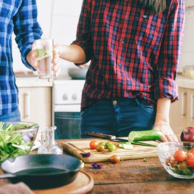 Çift sağlıklı hafif akşam yemeği evde mutfakta hazırlanıyor. Sağlıklı gıda kavramı.