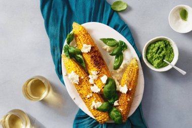 Fried Mısır pesto sos, peynir ve gri arka plan, üstten görünüm üzerinde plaka üzerinde beyaz şarap