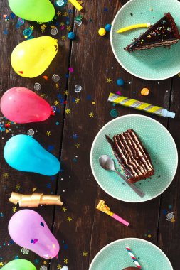 Çikolatalı kek ve dekorasyon parti kahverengi ahşap arka plan düz üzerinde yatıyordu. Üstten görünüm Çocuk Doğum günü tablo kavramı