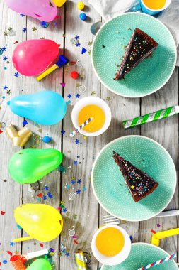 Üstten görünüm Çocuk Doğum masası. Çikolatalı pasta, kek ve dekorasyon parti ahşap zemin düz üzerinde yatıyordu