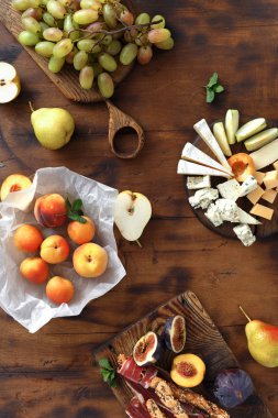 Şarap için meze tablo. Çeşitli aperatifler şarap: üzüm, şeftali, kayısı, armut, elma, jamon, sert peynir, brie peyniri ve Rokfor peyniri ahşap masa üstten görünüm üzerinde düz lay