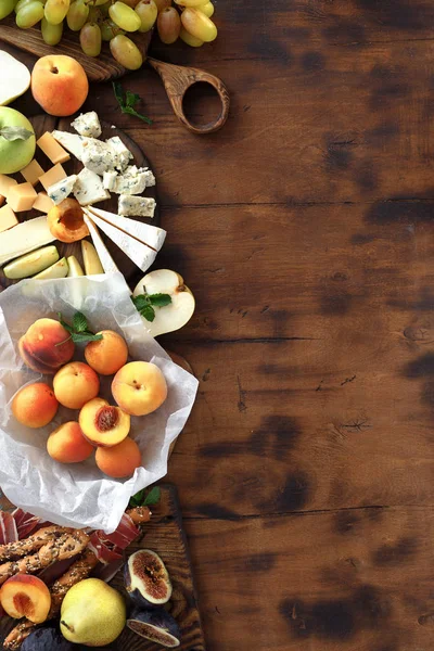 前菜テーブル境界線とワイン なワイン軽食 ブドウ ピーチ アプリコット リンゴ ハモン ハードタイプのチーズ ブリーチーズ 木製テーブル — ストック写真