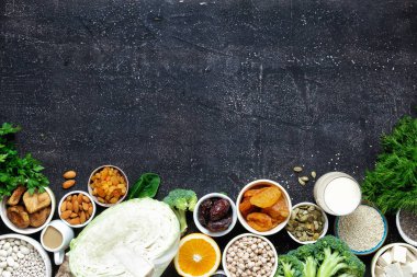 Vejetaryenler için kalsiyum kaynağıdır. Üstten görünüm sağlıklı gıda temizlik yemek: meyve, sebze, tohum, superfood, yaprak sebze kopya alanı ile koyu arka plan üzerinde