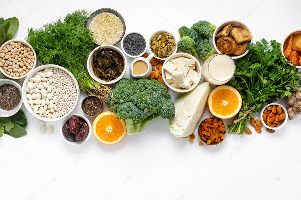 Source of calcium for vegetarians. Top view healthy food clean eating: fruit, vegetable, seeds, superfood, leaf vegetable on white background with copy space