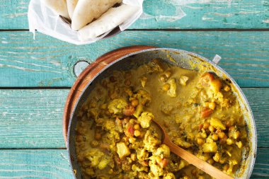 Karnabahar baharatlı köri tavada naan ekmek en iyi görünümü ile yeşil ahşap masa