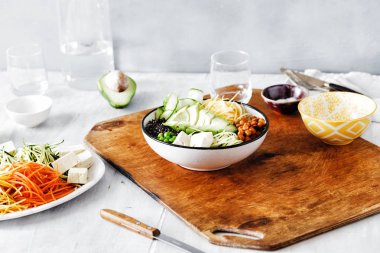 Vejetaryen Buda kase. Temiz sağlıklı gıda kavramı. Spiralized sebze, avokado, yeşil bezelye, salatalık, nohut ve beyaz ahşap masa üzerinde siyah quinoa