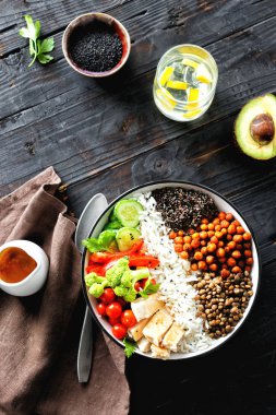 Buda kase. Temiz ve dengeli sağlıklı gıda kavramı. Pirinç, baharatlı nohut, siyah quinoa, sebze ve koyu ahşap arka plan, üstten görünüm üzerinde tavuk fileto