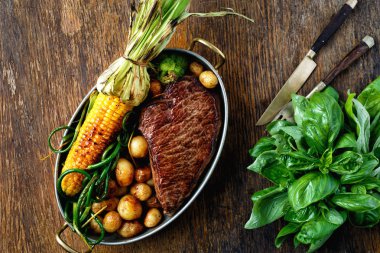 Sebze ahşap masa üstten görünüm üzerinde bir tavada kızarmış sığır eti biftek