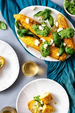 Pesto sos ve beyaz peynir ile kızarmış tatlı Mısır gri beton zemin üstten görünüm üzerinde bir tabakta servis edilir. Lezzetli meze