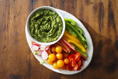 Ahşap masa üzerinde plaka üzerinde üstten görünüm sebze aperatifler pesto sos ile servis