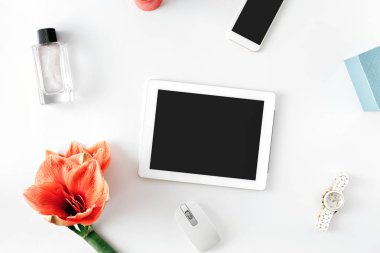 Düz yatıyordu, en iyi görünümü office tablo resepsiyon. Kadınsı Resepsiyon çalışma alanıyla çiçeği nergis zambağı, boş ekran, smartphone, Bayan kol saati ve kadın parfüm ile tablet