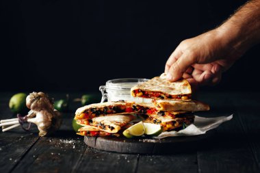 Koyu ahşap masa üzerinde vejetaryen meze: quesadilla sebze ve peynir koyu arka plan üzerinde
