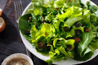 Koyu ahşap arka plan üzerinde keten tohumu ile taze yeşil salata tabak