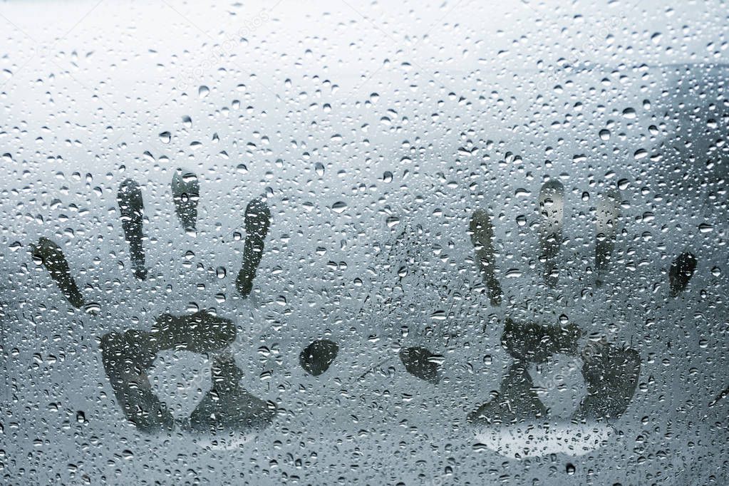 Two hand prints on wet glass