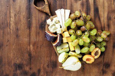 meze tablo: üzüm, şeftali, kayısı, armut, elma, sert peynir, brie peyniri ve Rokfor peyniri ahşap tablo