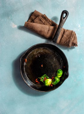 Mavi taş arka plan üstten görünüm üzerinde kızarmış Brüksel lahanası ile dökme demir tava