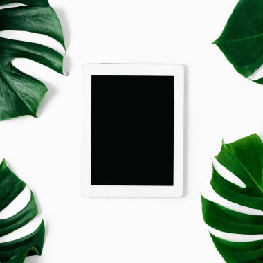 Beyaz tablet tropikal yaprak beyaz arka plan en iyi görünüm düz Monstera lay ile boş ekran ile