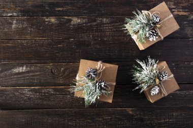 El yapımı Noel hediye kutuları koyu ahşap masa üstü görüntüsü düz üzerinde yatıyordu