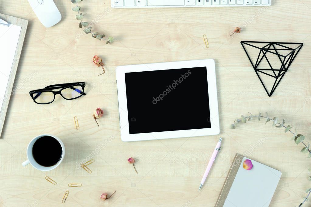 Feminine workspace with tablet with blank screen and accessories top view flat lay