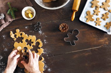 Noel gıda kavramı. Pişirme gingerbread adam çerezleri Noel ahşap masa üstten görünüm üzerinde dostum. Xmas tatlı