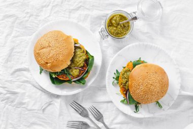 Üstten görünüm sağlıklı vejetaryen gıda kavramı. Vejetaryen burger kabak pirzola, ıspanak, roka ve pesto sos yapılmış plaka üstten görünüm üzerinde hizmet