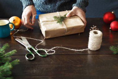 Erkek el ahşap masa üzerinde Noel hediye sarma