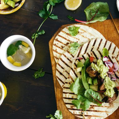 Yemek masası ile tacos ızgara sebze salsa, guacamole sos, tavuk ve limonata üstten görünüm 