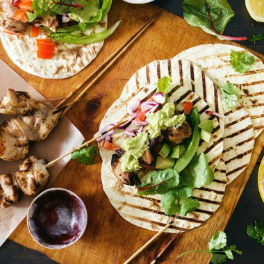 Üstten görünüm tacos ızgara tavuk koyu arka plan üzerinde sebze salsa, guacamole sos ile