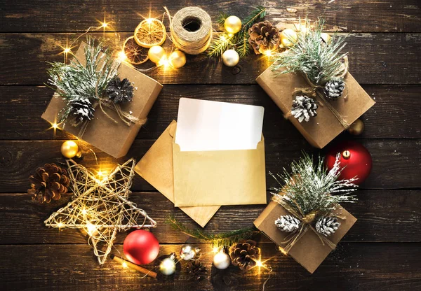 クリスマスの装飾のリースとサンタ クロースの封筒がなされ 暗い背景の木トップ ビュー フラットにクリスマス ライト クリスマスの背景を置く — ストック写真