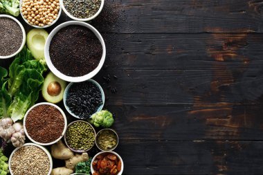 Superfoods koyu ahşap Tablo kopya alanı ile ayarlama. Yaprakları, tahıllar ve üstten görünüm tohum. Sağlıklı vejetaryen yemek