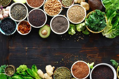 Kopya alanı koyu ahşap tablo set superfoods çerçevesinde. Yaprakları, tahıllar ve üstten görünüm tohum. Sağlıklı vejetaryen yemek