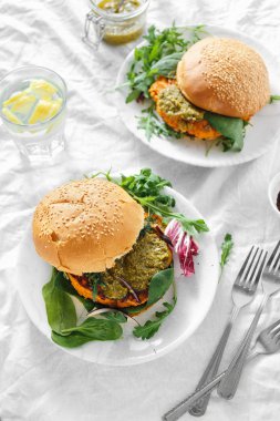 Vejetaryen burger kabak pirzola, ıspanak, roka ve pesto sos yapılmış tabaklarda servis