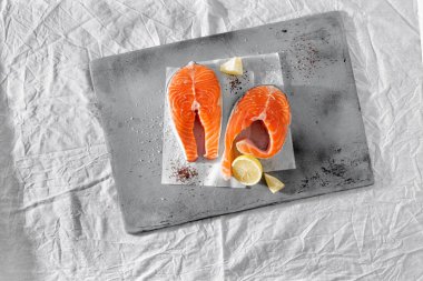 Biftek kayrak üzerinde limonlu taze çiğ Somon Balık