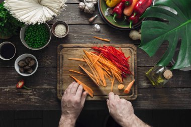 Ev mutfağında erkek eller vejetaryen Tay erişte koyu ahşap masa üstten görünüm üzerinde hazırlamak.