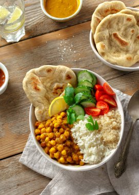 Ahşap masa üstten görünüm naan ekmek ile Vegan Buda kase. Sağlıklı vejetaryen gıda kavramı