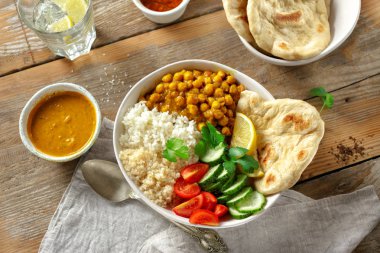 Ahşap masa üstten görünüm naan ekmek ile vejetaryen Buda kase. Sağlıklı vejetaryen gıda kavramı