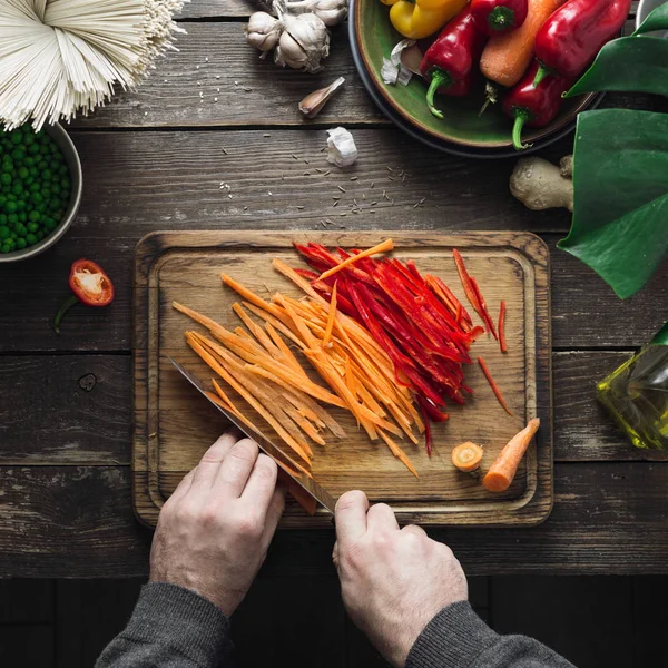 Üstten görünüm erkek eller koyu ahşap masa üstten görünüm üzerinde vejetaryen Tay noodles hazırlamak