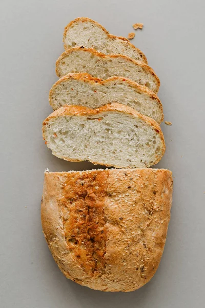 Loaf bread with slices bread on stone background