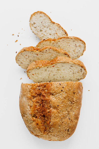 Loaf bread with slices bread on stone background