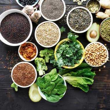 Dengeli beslenme gıda ham tohumlar, tahıl, fasulye, superfoods ve koyu ahşap masa üstü yeşil sebze görüntüleyin. Vejetaryen veya diyet gıda
