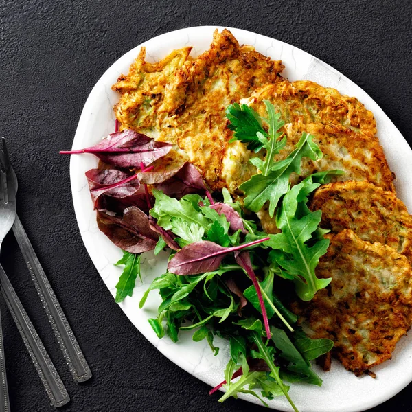 Stekt Zucchini Pannkakor Som Serveras Tallrik Med Sallad Mörk Bakgrund — Stockfoto