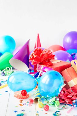 Doğum günü partisi arka plan dekorasyon, balon, konfeti, serpantin, Beyaz ahşap teble doğum günü şapkası ve hediye kutuları ile
