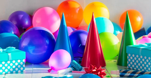 Decoration party background. Birthday background. Many colorful balloons, confetti, gift and birthday hat