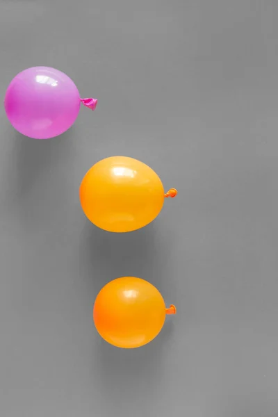 Orange and purple balloons in gray background